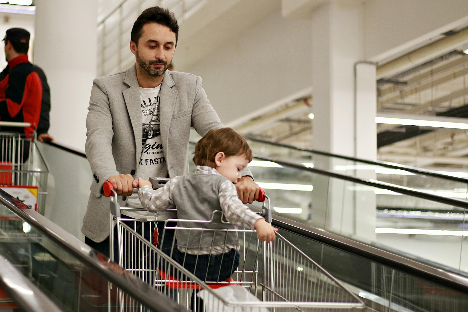 Jesienne atrakcje w Pasażu Meteor w Zielonej Górze: zakupy, wydarzenia rodzinne i strefy relaksu Mężczyzna z dzieckiem w wózku na ruchomych schodach w galerii handlowej