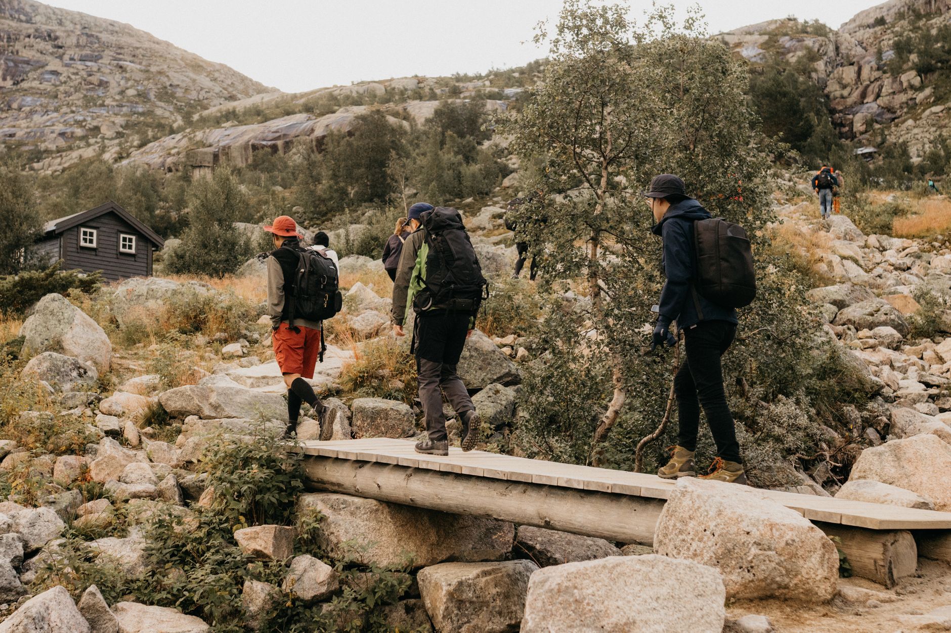 Turyści na drewnianym moście podczas letniego trekkingu w norweskich górach