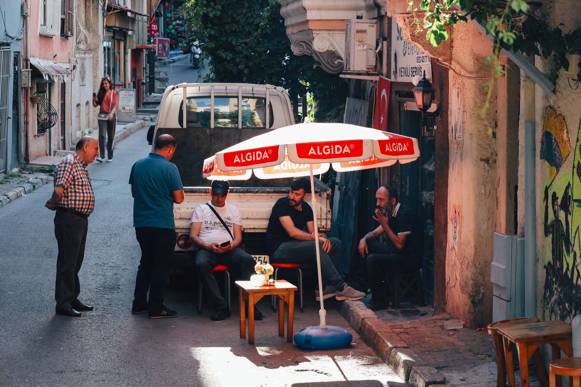 Istanbul poza TOP 10 atrakcji: dzielnice, w których toczy się codzienne życie miasta Mężczyźni odpoczywający pod parasolem Algida na ulicy w Stambule