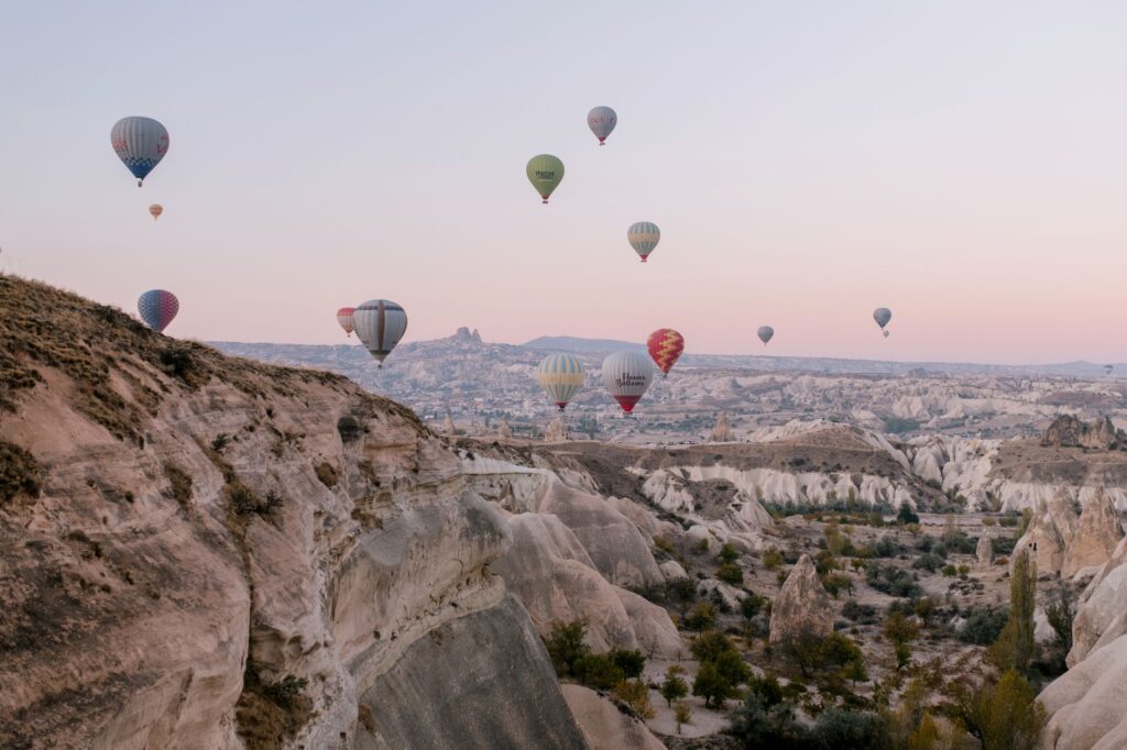 Balony na ogrzane powietrze nad formacjami skalnymi Kapadocji o wschodzie słońca